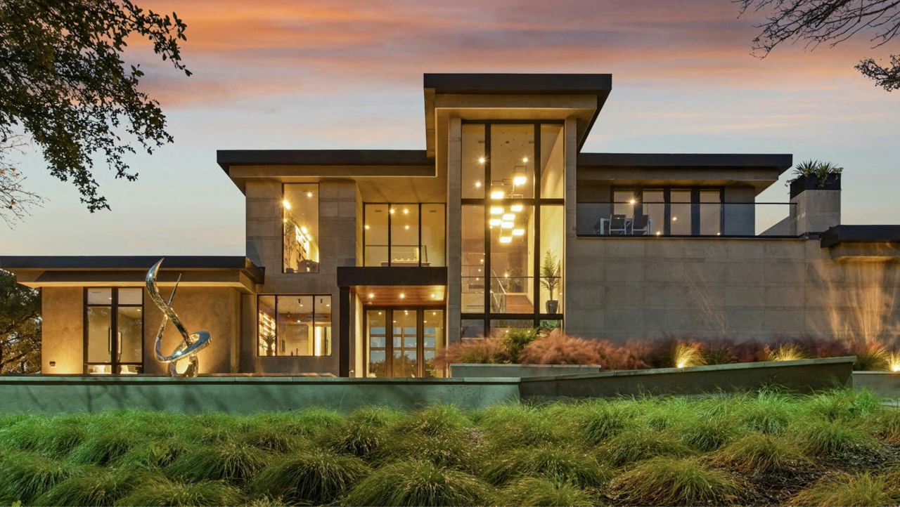 Modern detached house at dusk with illuminated windows